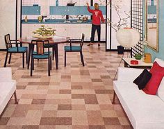 a woman is standing in the middle of a room with blue walls and checkered flooring