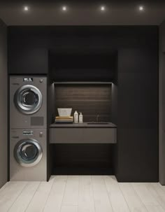 a washer and dryer in a room with dark walls, flooring and lighting