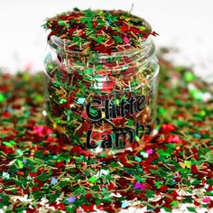 a jar filled with lots of confetti next to a pile of sprinkles