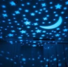 a room with stars and moon projected on the ceiling