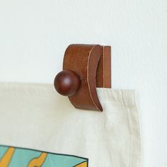 a bag hanging on the wall with a wooden handle