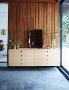 a large wooden dresser sitting in the middle of a living room next to a sliding glass door