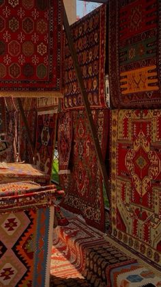 many colorful rugs are stacked on top of each other in an area that looks like it has been made out of wood