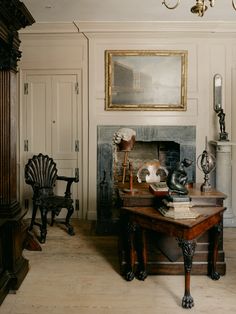 a living room filled with furniture and a fire place next to a painting on the wall