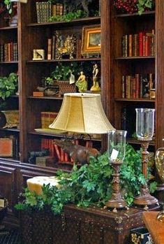 a lamp sitting on top of a table in front of a book shelf filled with books