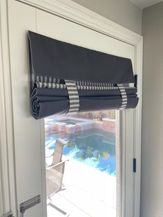 a black and white striped window valance hanging from the side of a sliding glass door