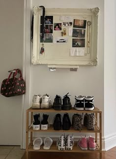 shoes are lined up on a shelf in front of a wall with a mirror above it