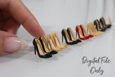 a hand is pointing at four pairs of high heel shoes that are lined up in the same row