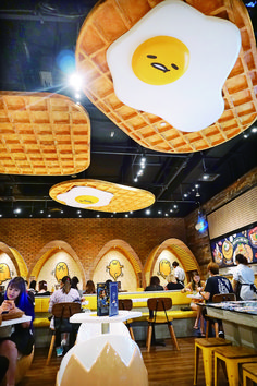 people sitting at tables in a restaurant with large waffles hanging from the ceiling