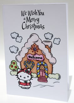 a hello kitty christmas card with a gingerbread house on the front and welcome sign in the back