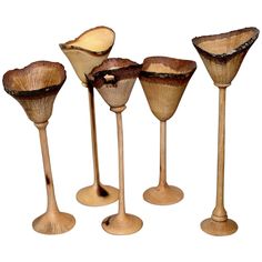 four wooden wine goblets are lined up in a row on a white background