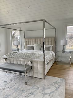 a bedroom with a four poster bed in the middle and a rug on the floor