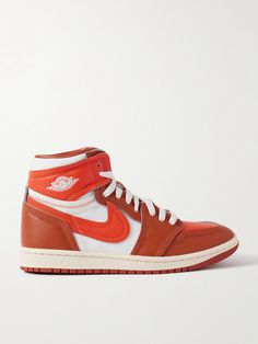 Nike's 'Method of Make' line takes iconic sneakers and elevates them with luxurious materials and details. Part of the series, this 'Air Jordan 1' pair is made from layered panels of leather and twill in a vibrant orange colorway. Show off the high-top profile with shorts or cropped pants. Luxury Nike Sneakers For Sports, Luxury Nike Custom Sneakers For Streetwear, Nike Luxury Leather Sneakers, Leather High-top Sneakers For Sports With Branded Heel Counter, Nike Leather High-top Sneakers With Abzorb Midsole, Luxury High-top Custom Sneakers With Translucent Outsole, Luxury Custom High-top Sneakers With Translucent Outsole, Luxury Orange Sneakers, Nike Custom Leather High-top Sneakers