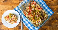 a glass casserole dish with pasta and vegetables on a blue checkered tablecloth