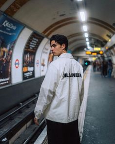 a man standing in front of a subway platform