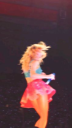 a woman in a red skirt is dancing on stage