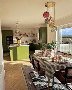 the dining room table is set with place settings for four people and has green cabinets