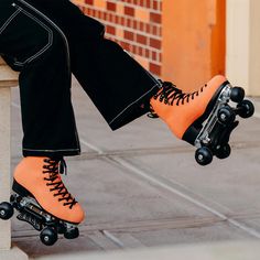 a person wearing orange roller skates and black pants