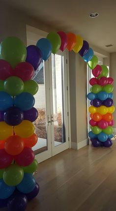 a bunch of balloons that are on the ground in front of some doors and windows