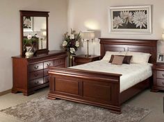 a bed room with a neatly made bed and dressers