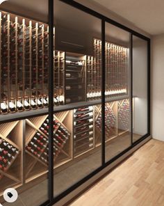 there is a wine cellar with many bottles on the wall and behind it are glass doors that open to let in plenty of light