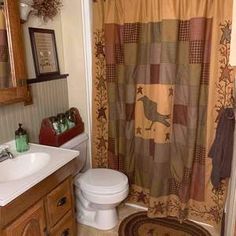 a bathroom with a toilet, sink and shower curtain in it's center area