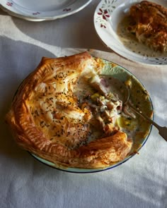 there is a pie on the plate with a fork in it and another dish next to it