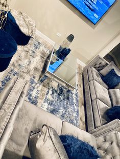 a living room filled with furniture and a flat screen tv mounted above the couches