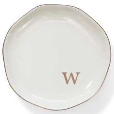 a white and gold plate with the letter w on it's side, in front of a white background