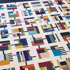 a very large quilt with many different colored squares on it's sides and bottom