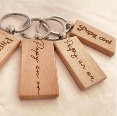 wooden keychains with engraved names on them sitting on a white sheet that says, dopp cou