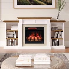 a living room with a fire place and books on the coffee table in front of it