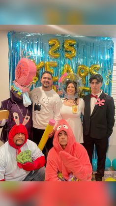 a group of people standing next to each other in front of balloons and streamers