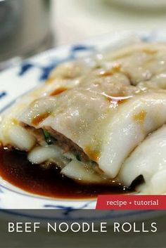 a close up of a plate of food with meat and sauce on the side that says beef noodle rolls