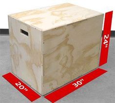 a wooden box sitting on top of a floor next to red measuring tape and numbers