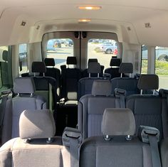 the interior of a vehicle with several seats in front of it and two rows of windows on each side