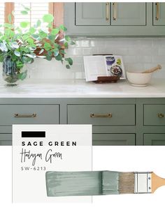 sage green kitchen cabinets with white counter tops and gold pulls on the handles, along with a painting brush