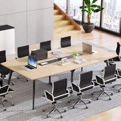 an office table with chairs and laptops on it