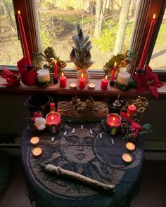 a table topped with candles next to a window