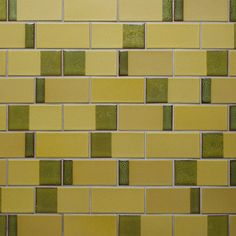 a yellow and green tiled wall with small squares