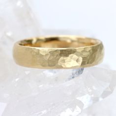 a close up of a gold wedding ring on top of some ice flaker