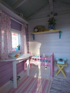 a small child's room with pink and white decor, including a desk and chair