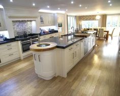 a large kitchen with white cabinets and black counter tops, along with an island in the middle