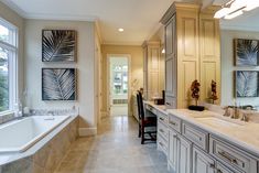 a large bathroom with two sinks and a bathtub next to a long counter top