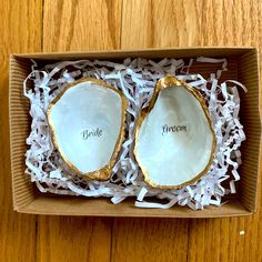 two open oysters in a cardboard box with white shredded paper on the bottom and inside