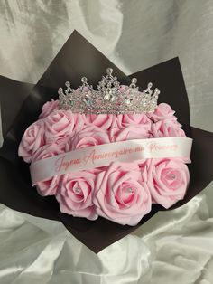 a bouquet of pink roses with a tiara on top