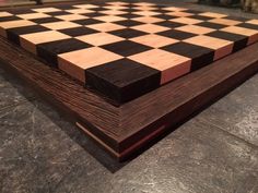 a wooden chess board sitting on top of a table