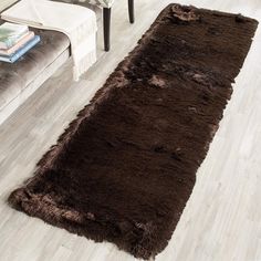 a brown rug is on the floor next to a chair