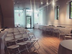 an empty room with white chairs and tables