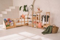 a white room with shelves and baskets on the floor, bookshelf in the corner